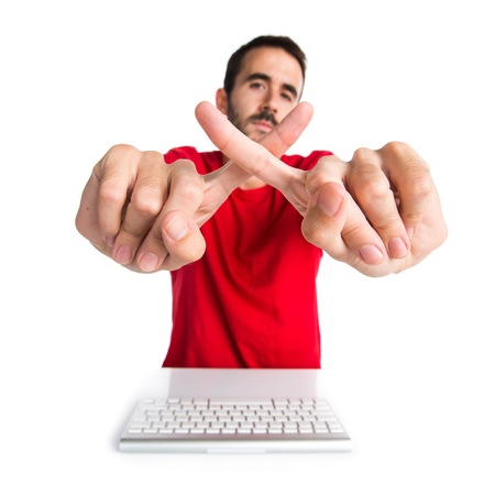 Computer technician working with his keyboard making NO gestureの写真素材