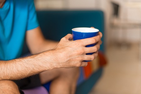 Man in an apartment holding a cup of coffeeの写真素材