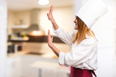 Beautiful chef woman pushing something in the kitchenの写真素材