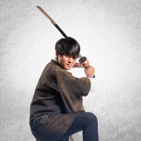 Asian samurai man with katana on textured backgroundの写真素材