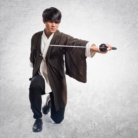 Asian samurai man with katana on textured backgroundの写真素材
