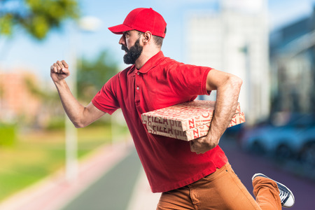 Pizza delivery man running fastの写真素材