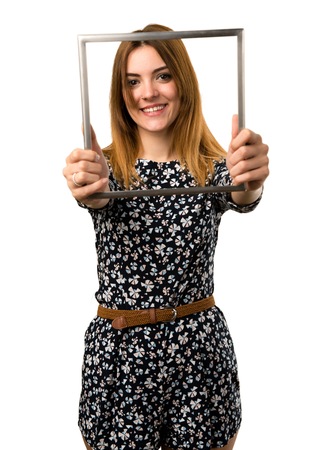 Beautiful young girl looking through an iron frameの写真素材