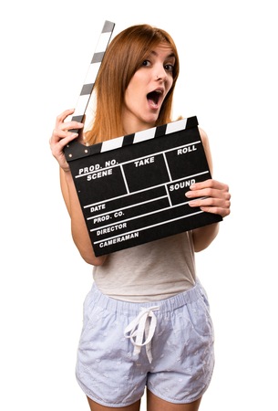 Beautiful girl in pajamas holding a clapperboardの写真素材