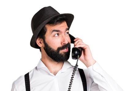 Hipster man with beard talking to vintage phoneの写真素材