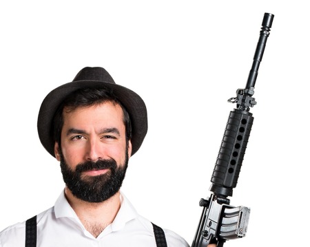 Hipster man with beard holding a rifleの写真素材