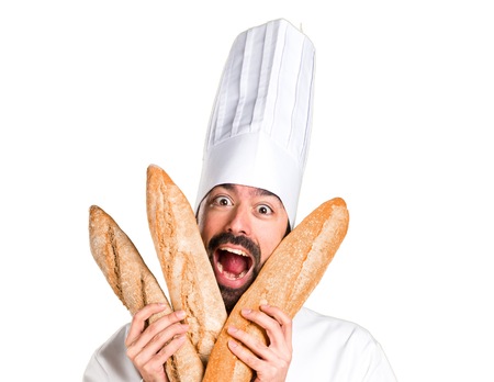 Crazy young baker holding some breadの写真素材