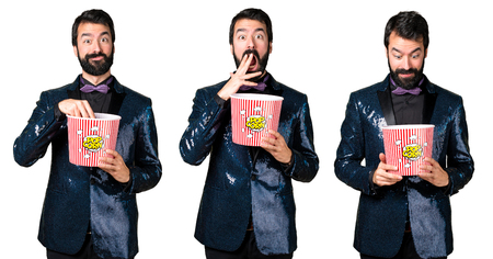 Handsome man with sequin jacket eating popcornsの写真素材