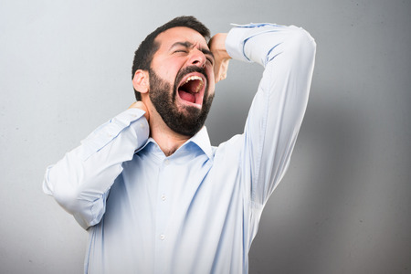 Handsome man with beard yawning on textured backgroundの写真素材