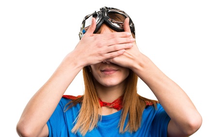 Pretty superhero girl covering her eyesの写真素材