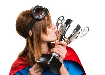 Pretty superhero girl holding a trophyの写真素材