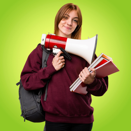 Student woman holding a megaphone on colorful background