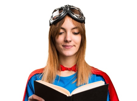 Pretty superhero girl reading bookの写真素材