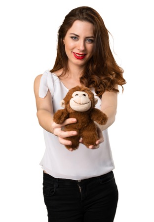 Beautiful young girl playing with a little stuffed animalの写真素材