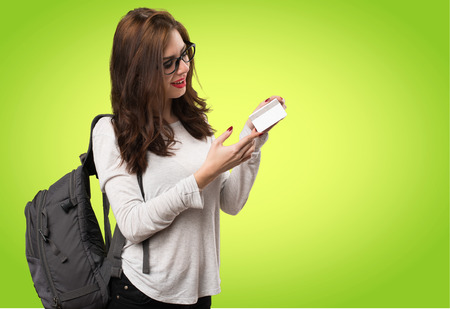 Student woman holding a credit card on colorful backgroundの写真素材