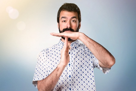 Handsome brunette man with beard making time out gestureの写真素材
