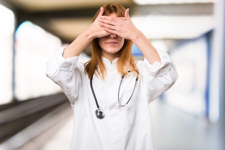 Young doctor woman covering her eyes in the hospitalの写真素材