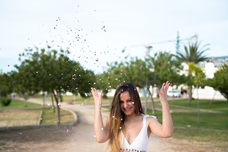 Beautiful young girl in a park with confettiの写真素材