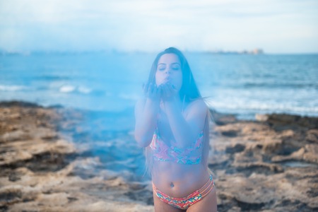 Beautiful young girl in the beach with blue color holi