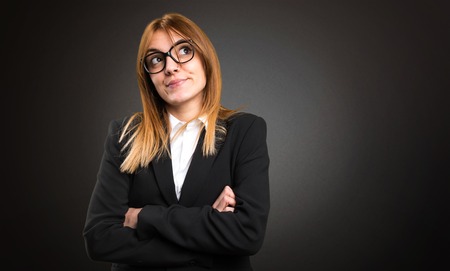Young business woman making unimportant gesture on dark backgroundの写真素材
