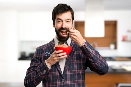 Happy Well dressed man holding a bowl of cereals inside house