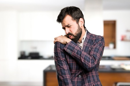 Well dressed man with shoulder pain inside houseの写真素材