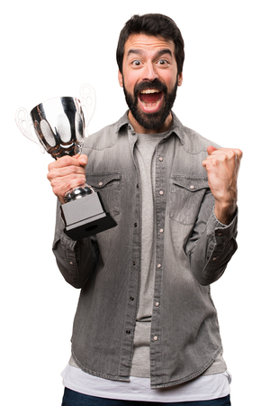 Handsome man with beard holding a trophy on white backgroundの写真素材