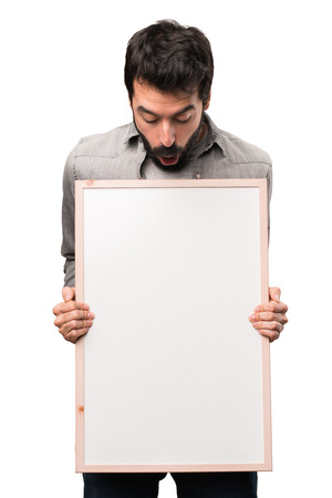 Handsome man with beard holding an empty placard on white backgroundの写真素材