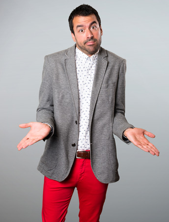 Handsome man making unimportant gesture on grey backgroundの写真素材