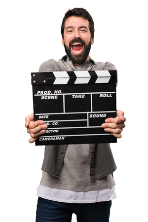 Handsome man with beard holding a clapperboard on white backgroundの写真素材