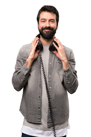 Handsome man with beard listening music on white backgroundの写真素材