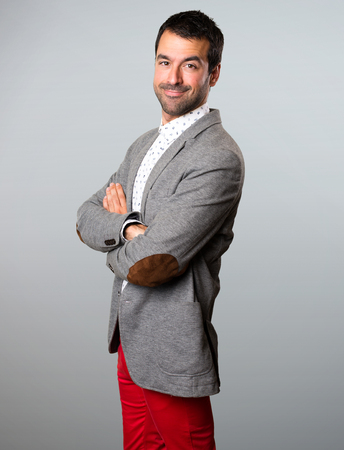 Handsome man with his arms crossed on grey backgroundの写真素材