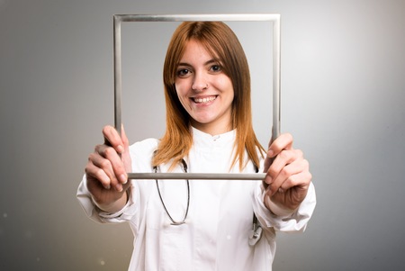 Young doctor woman with framework on grey backgroundの写真素材