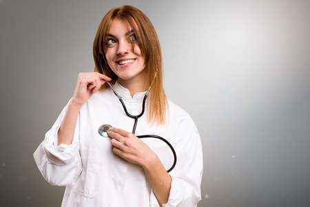 Young doctor woman on grey backgroundの写真素材