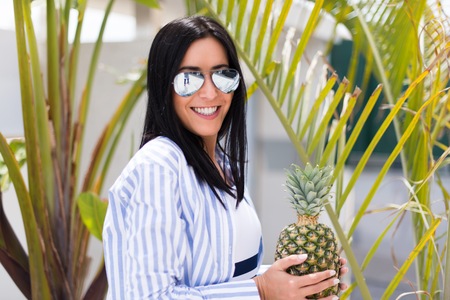 Beautiful young girl with a pineapple