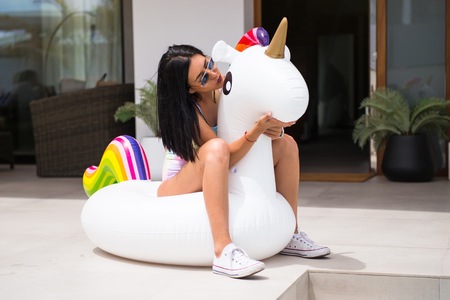 Beautiful young girl with unicorn floatの写真素材