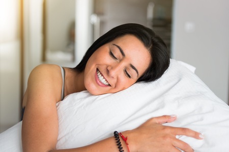 Beautiful young girl in her bedの写真素材