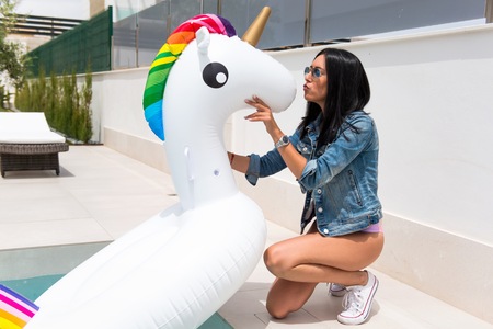 Beautiful young girl with unicorn floatの写真素材