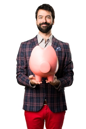 Happy Well dressed man holding a piggybank on white backgroundの写真素材