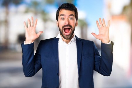 Handsome man making surprise gesture on unfocused backgroundの写真素材