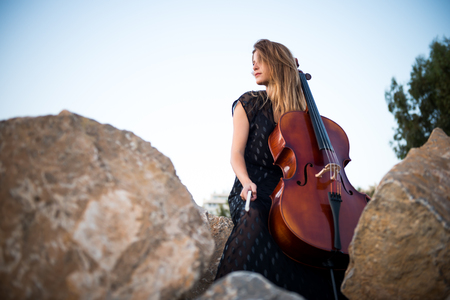 Young beautiful girl with her cello on the outsideの写真素材