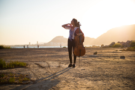 Young beautiful girl with her cello on the outsideの写真素材
