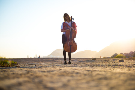 Young beautiful girl with her cello on the outsideの写真素材
