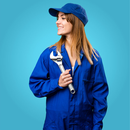 Delivery woman looking lateral on colorful backgroundの写真素材