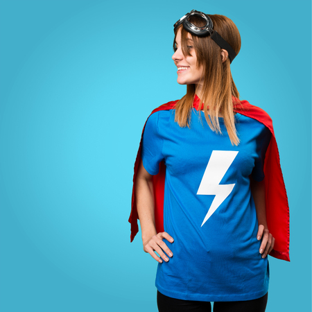 Pretty superhero girl looking lateral on colorful backgroundの写真素材