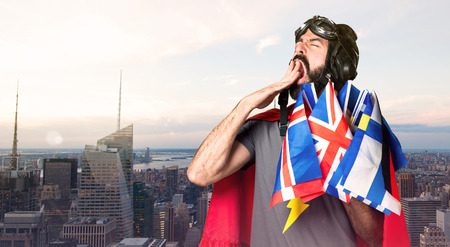 Superhero with a lot of flags yawning on unfocused city backgroundの写真素材