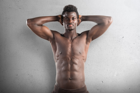 Strong black man posing in studio on textured backgroundの写真素材