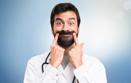 Happy young doctor on blue background