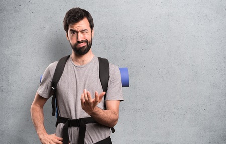 Tired handsome backpacker on textured backgroundの写真素材
