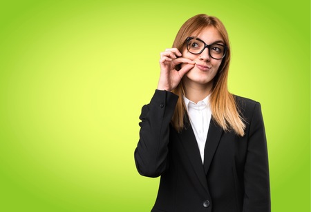 Young business woman making silence gesture on colorful backgroundの写真素材